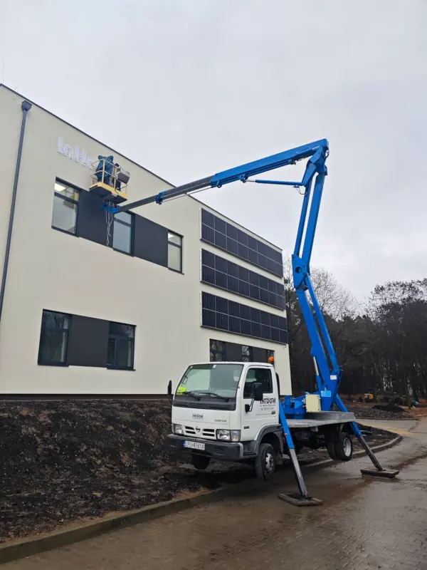 Usługi podnośnikowe na pochylonym terenie z użyciem zwyżki IntDom.